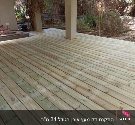דק עץ חדש בגינה עם עמודים ותאורה